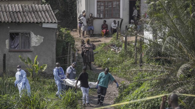 South African forensic pathology personnel are assisted by community members to carry the body of a victim following a mass shooting in the Ziko area of KwaMakhutha, south of Durban on September 23, 2026. Armed men stormed a home in the South African