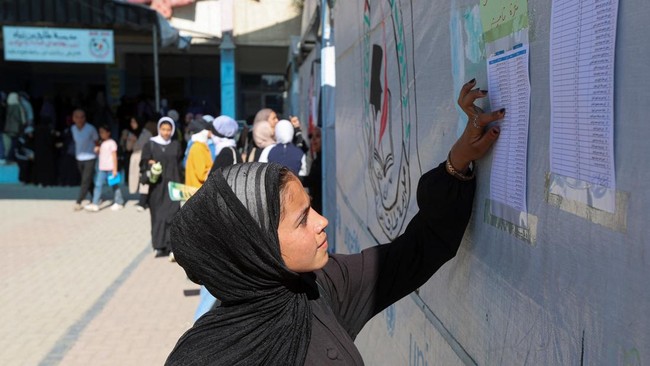 Displaced Palestinian student Samar Abu Salmi, 15, reads a list of names displayed in a school in Khan Younis, in the southern Gaza Strip, September 20, 2026. REUTERS/Ramadan Abed