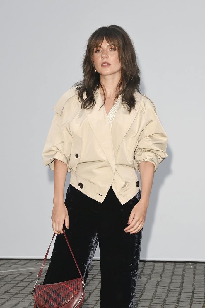 Emily Bader memusatkan perhatian gayanya pada shoulder bag Burberry berwarna merah dengan motif check yang semakin mencolok ketika dipadu padan dengan busana berwarna netral/ Foto: Courtesy of Burberry/Dave Benett/Dave Benett