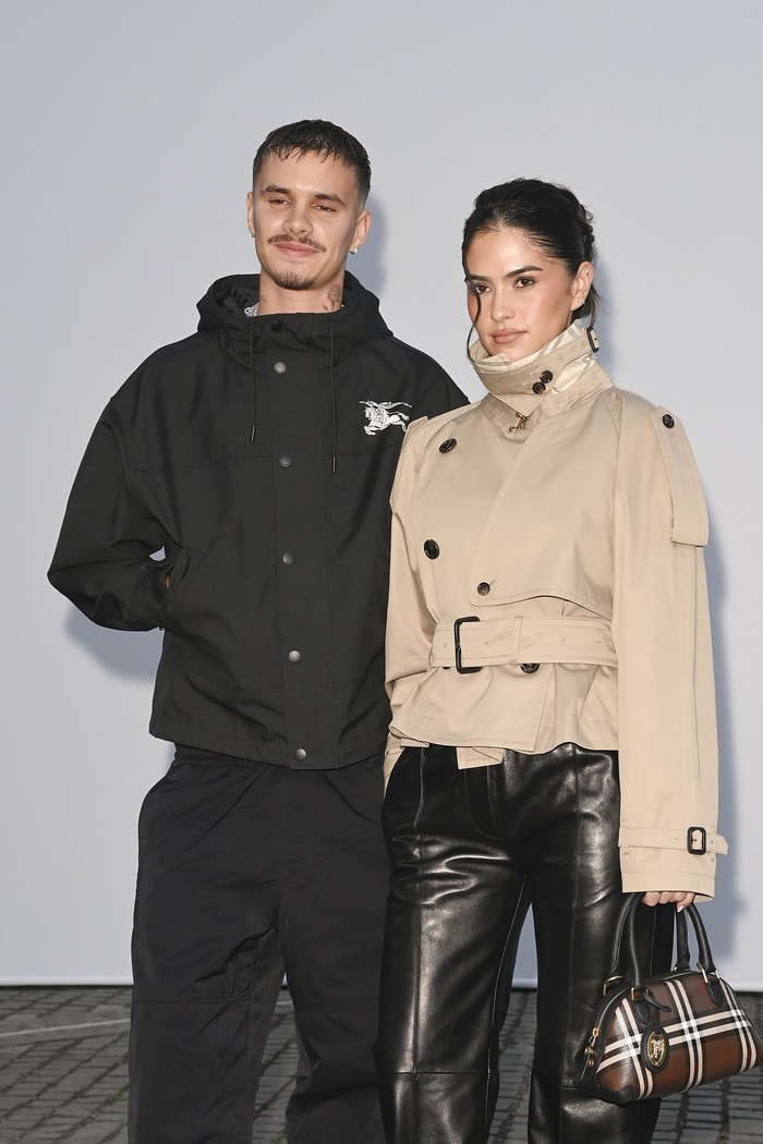 Romeo Beckham&nbsp;dan Kim Turnbull turut hadiri peragaan busana Burberry Summer 2027, Beauties. Keduanya mengenakan jaket dengan kerah tinggi bergaya utilitarian, namun dalam warna kontras, yakni hitam dan beige./ Foto: Courtesy of Burberry/Dave Benett/Dave Benett