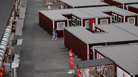 Asian Games - Aichi-Nagoya 2026 - Previews - Nagoya, Japan - September 18, 2026 General view of people outside wooden container units in the Athletes' Village ahead of the games REUTERS/Anushree Fadnavis