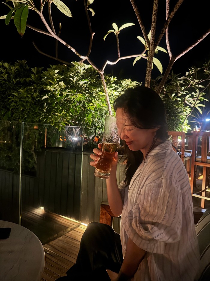 Minuman bir telah menjadi ciri khas orang Korea dalam menutup hidangan makan malam lezat yang juga direpresentasikan Hyoyeon dalam potret bahagianya saat menyaksikan keindahan malam Pulau Bali di sebuah cafe./ Foto: instagram.com/hyoyeon_x_x