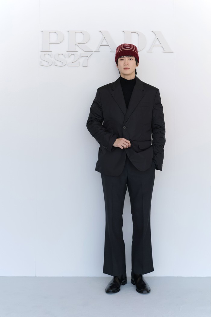 Jaehyun menghadiri fashion show Prada dengan beanie maroon yang curi perhatian. Aksesori itu menjadi sentuhan kasual pada outfit setelan jas serba hitam yang dikenakannya/ Foto: Courtesy of Prada
