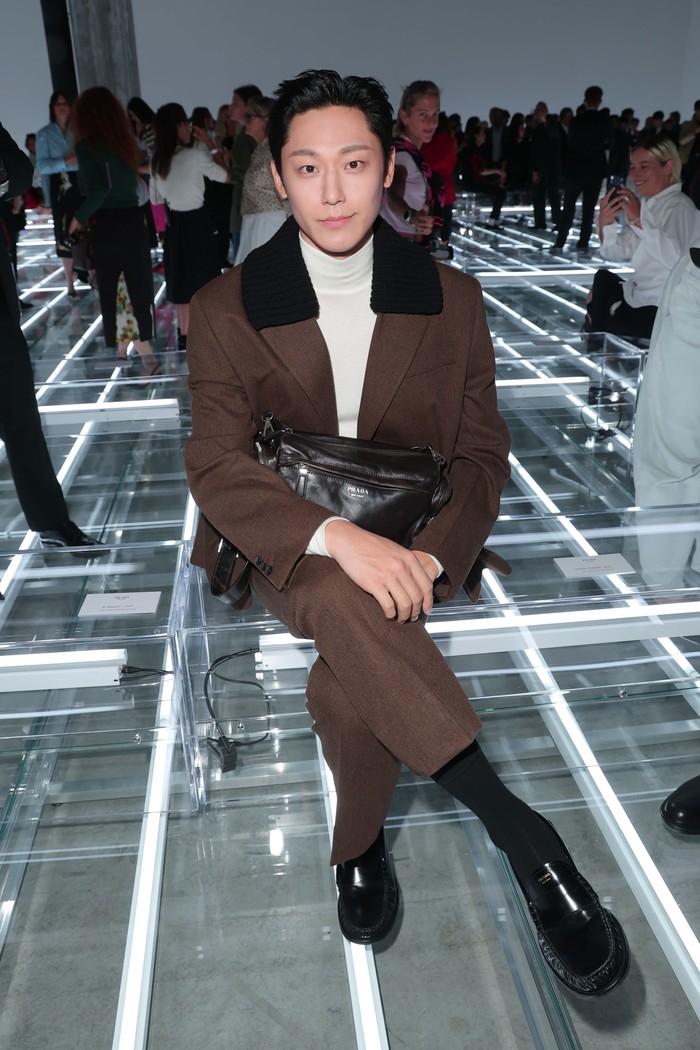 Lee Do-Hyun tampil rapi dalam setelan jaket dan tailored pants coklat yang dipadukan dengan atasan turtleneck/ Foto: Courtesy of Prada