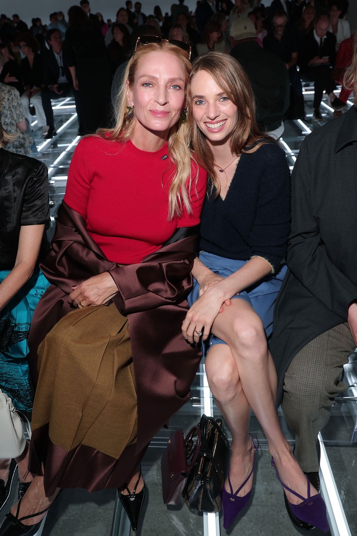 Mother-daughter moment! Uma Thurman dan Maya Hawke menyaksikan presentasi koleksi Prada SS27 bersama. Bintang film Kill Bill  mengenakan busana yang berani lewat warna, yakni sweater merah yang dipadukan pleated skirt two-toned dan coat. Sementara Maya mengenakan V-neck sweater navy blue dan bermuda shorts/ Foto: Courtesy of Prada