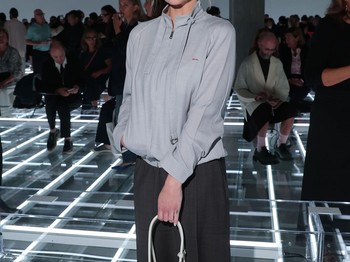 Gaya yang santai dan sporty diadopsi Emilia Clarke. Aktris asal Inggris itu mengenakan rok selutut dan jaket dengan aksen tali dalam warna abu-abu yang serasi. Mempermanis tampilan, ia menggenggam shoulder bag berstruktur rona putih, sedangkan sunglasses sebagai sentuhan vintage/ Foto: Courtesy of Prada