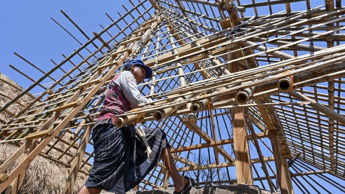 Warga memasang rangka atap dari bambu untuk bangunan rumah adat pascakebaran di Kampung adat Sade, Desa Rembitan, Kecamatan Pujut, Praya, Lombok Tengah, NTB, Sabtu (26/9/2026). Warga terdampak kebakaran di Kampung adat Sade mulai membangun kembali ru