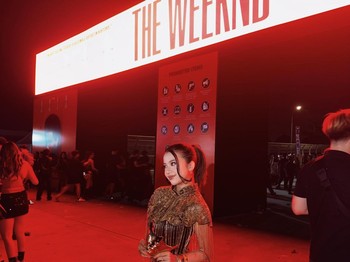 Diva Azzura tampil stylish saat menonton konser The Weeknd di Jakarta. Ia mengenakan atasan gold berhias fringe, mini shorts hitam, sheer tights, dan knee-high boots yang menciptakan kesan glamor dan edgy/Foto: Instagram/diva.azzura