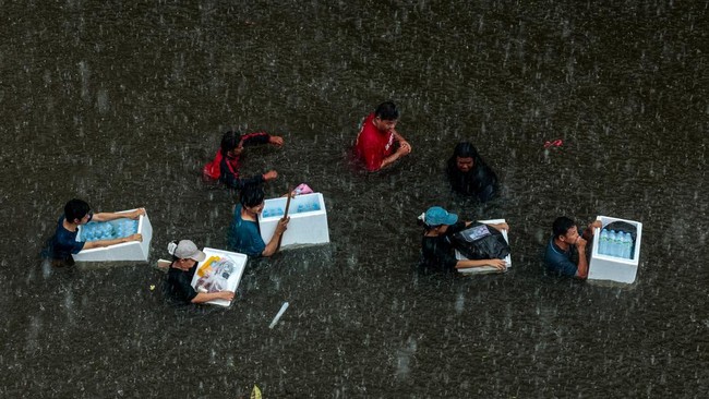 People wade through a flooded area during heavy rain in Bangkok, Thailand, September 27, 2026. REUTERS/Patipat Janthong     TPX IMAGES OF THE DAY