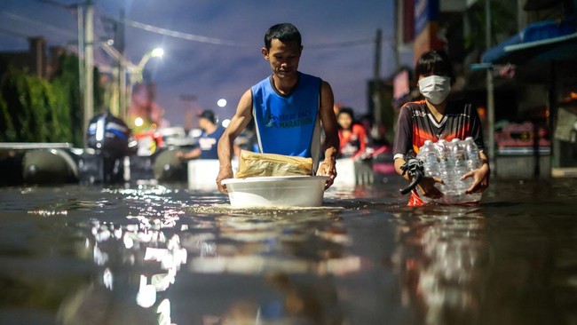 People wade through a flooded area during heavy rain in Bangkok, Thailand, September 27, 2026. REUTERS/Patipat Janthong