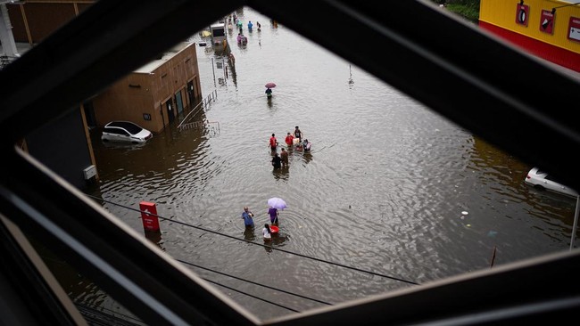 People wade through a flooded area, in Bangkok, Thailand, September 28, 2026. REUTERS/Athit Perawongmetha
