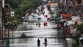 People wade through a flooded area, in Bangkok, Thailand, September 28, 2026. REUTERS/Athit Perawongmetha
