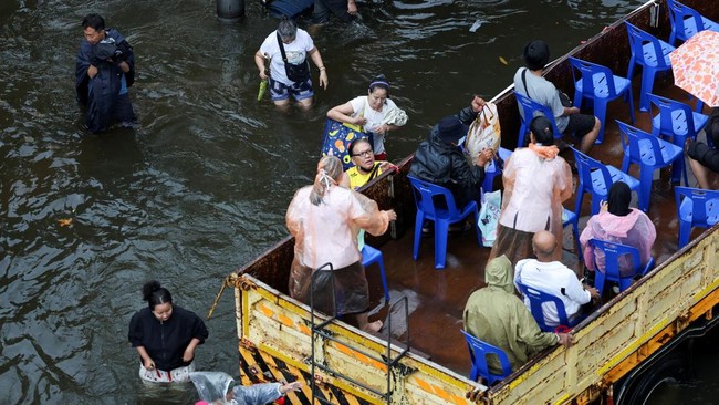 People board a truck equipped with plastic chairs to commute through a flooded area, in Bangkok, Thailand, September 28, 2026. REUTERS/Athit Perawongmetha     TPX IMAGES OF THE DAY