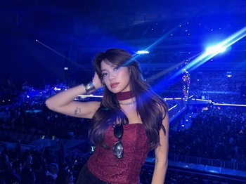Regina Phoenix tampil feminin dan glamor saat menonton konser The Weeknd di Jakarta. Ia mengenakan bustier lace burgundy yang dipadukan dengan rok mini hitam bertekstur sequin, serta aksesori silver yang melengkapi penampilannya/Foto: Instagram/reginaaphx