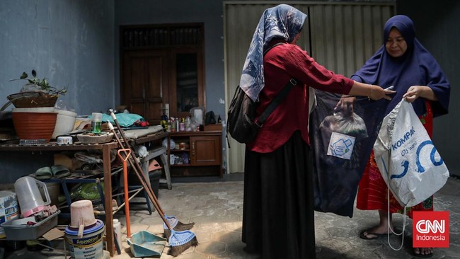 Sejumlah penyuluh menyosialisasikan pemilahan sampah sekaligus membagikan wadah pemilahan kepada warga di RW 06 Srengseng Sawah, Jagakarsa, Jakarta Selatan, Senin (28/9). (CNN Indonesia/Febria Adha L)