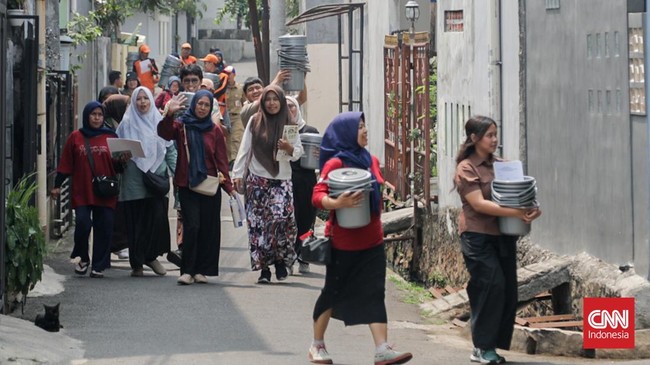 Sejumlah penyuluh menyosialisasikan pemilahan sampah sekaligus membagikan wadah pemilahan kepada warga di RW 06 Srengseng Sawah, Jagakarsa, Jakarta Selatan, Senin (28/9). (CNN Indonesia/Febria Adha L)