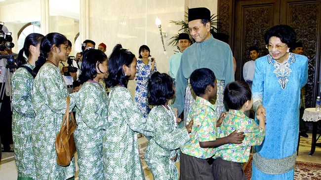 Malaysian Prime Minister Mahathir Mohamad and his wife Siti Hasmah greets children from an orphanage 08 January 2000 at his new residence in Putrajaya on the first day of the Muslim Eid al-Fitr celebration.  Mahathir opened his new house to the publi