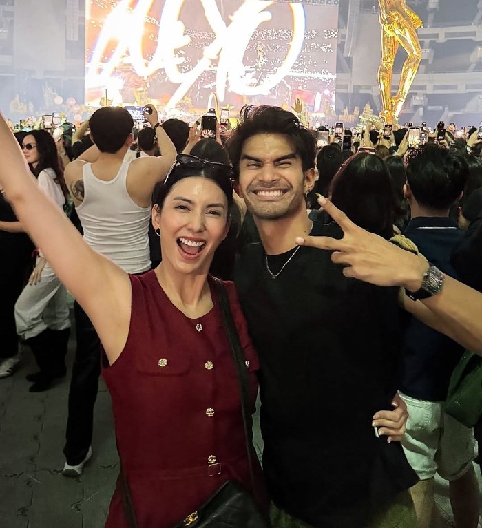 Tyas Mirasih memilih tampilan feminin bernuansa burgundy saat menyaksikan konser The Weeknd di Jakarta. Detail kancing gold dan tas hitam menjadi aksen yang mempermanis penampilannya/Foto: Instagram/tyasmirasih
