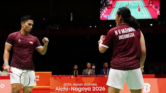 Indonesia's Amri Syahnawi (L) and Nita Violina Marwah react after taking a point against China's Jiang Zhenbang and Wei Yaxin in the mixed doubles badminton final during the 2026 Asian Games at the Ichinomiya City Municipal Gymnasium in Ichinomiya, A
