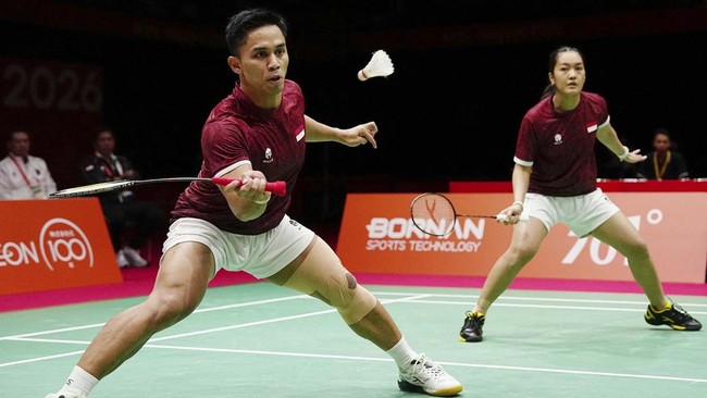 Indonesia's Amri Syahnawi (L) and Nita Violina Marwah play a point against China's Jiang Zhenbang and Wei Yaxin in the mixed doubles badminton final during the 2026 Asian Games at the Ichinomiya City Municipal Gymnasium in Ichinomiya, Aichi prefectur