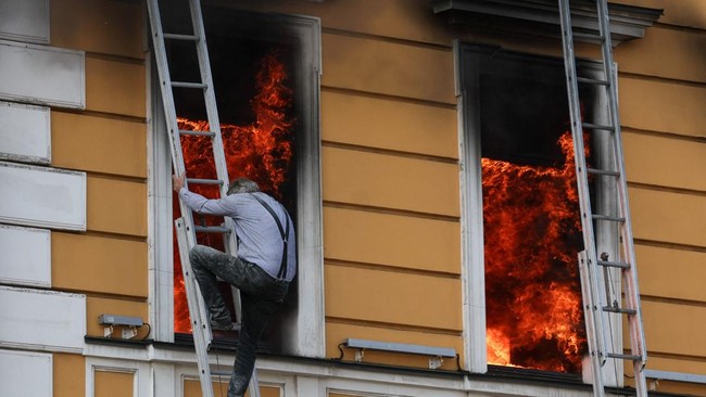 A man tries to evacuate an administrative building hit by a Russian jet-powered drone strike, amid Russia's attack on Ukraine, in Kyiv, Ukraine, September 28, 2026. REUTERS/Gleb Garanich