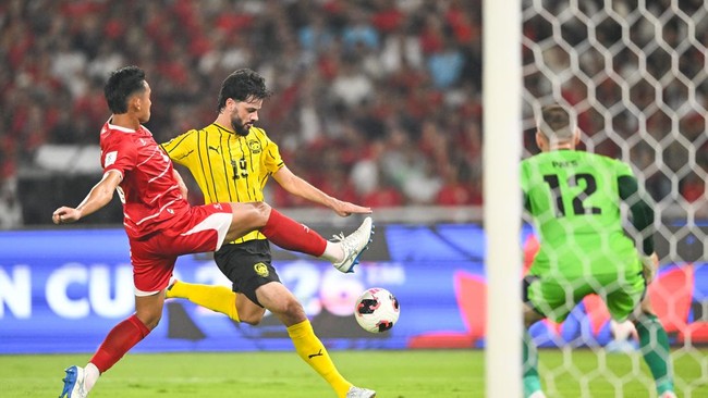 Pesepak bola Tim Nasional Indonesia Rizky Ridho (kiri) berusaha menghalangi tendangan pesepak bola Tim Nasional Malaysia Paulo Josue (kanan) dalam pertandingan penyisihan Grup A FIFA ASEAN Cup 2026 di Stadion Utama Gelora Bung Karno (SUGBK), Senayan,
