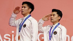 Gold medallists Indonesia's Daniel Marthin (L) and Leo Carnando salute on the podium after the men's doubles event during the 2026 Asian Games at the Ichinomiya City Municipal Gymnasium in Ichinomiya, Aichi prefecture on September 29, 2026. (Photo by