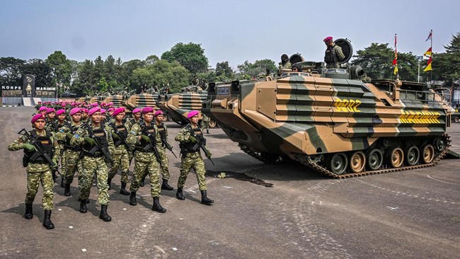 Prajurit Korps Marinir TNI AL berjalan di dekat kendaraan tempur amfibi AAV M-35 di Markas Komando Korps Marinir, Cilandak, Jakarta.