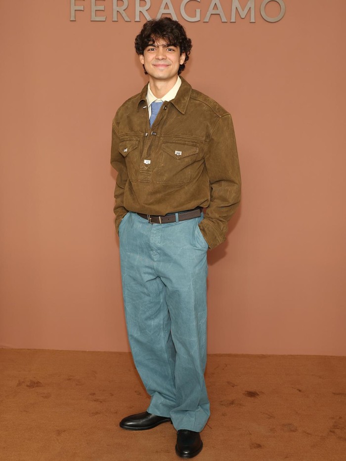 Bintang One Piece Live Action, I&ntilde;aki Godoy, menampilkan gaya bernuansa retro. Jaket coklat melapisi kemeja dan dasi biru, kemudian dipadu dengan celana panjang biru dengan efek washed/ Foto: Courtesy of Ferragamo Getty Images for Ferragamo /Daniele Venturelli