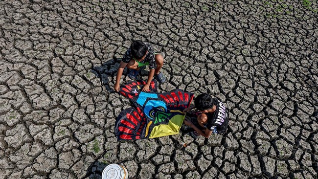 Dua anak bermain layang-layang di area Waduk Sumberkepuh yang mengering di Lengkong, Nganjuk, Jawa Timur, Minggu (6/9/2026).