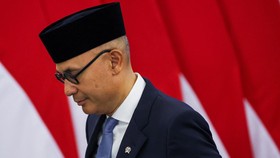 Indonesian Foreign Minister Arrmanatha Nasir walks near Indonesian flags following his inauguration at the State Palace in Jakarta, Indonesia, October 1, 2026. REUTERS/Ajeng Dinar Ulfiana