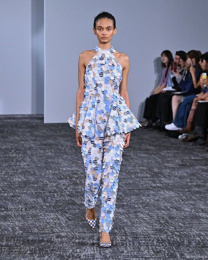 Teknologi 3D printing menjadi salah satu eksperimen utama ANREALAGE Spring/Summer 2027 melalui bustier dress bertekstur yang dapat berubah warna. Efek visualnya menyerupai Op Art karena warna berubah mengikuti sudut pandang penonton./ Foto: instagram.com/anrealage_official