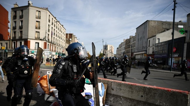 French gendarmes run amid clashes during a protest by high school students near the Lycee Berthelot high school in Aubervilliers near Paris as part of nationwide protests to demand the hiring of substitute teachers, increased resources and better lea