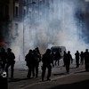French gendarmes walk through tear gas amid clashes during a protest by high school students near the Lycee Berthelot high school in Aubervilliers near Paris as part of nationwide protests to demand the hiring of substitute teachers, increased resour