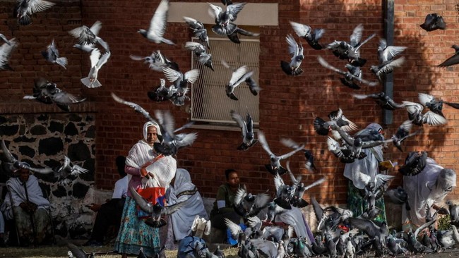 Doves take flight as a woman walks at Orthodox Enda Mariam Cathedral in Asmara, Eritrea, June 18, 2026. Eritrea has long been isolated by the West, which views the East African country as among the most repressive in the world, while the government i
