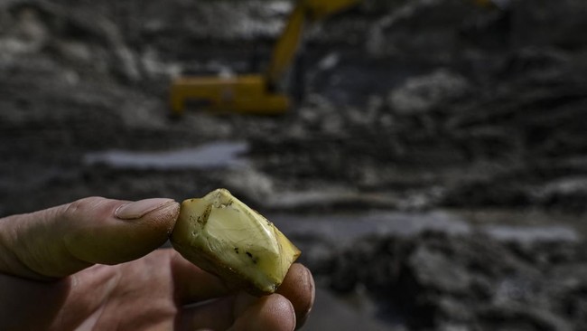A worker shows a piece of amber at the official open cast mine in the Rivne region, northwestern Ukraine on May 19, 2026. Russia's invasion has hit efforts to regulate the industry in Ukraine, which has some of the world's biggest reserves of amber.