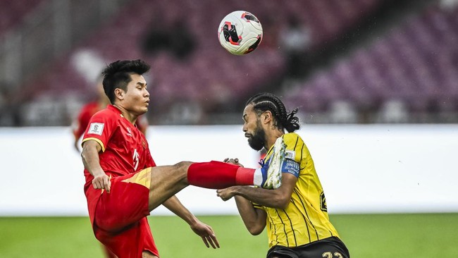 Pesepak bola Timnas Malaysia La'Vere Corbin-Ong (kanan) berebut bola dengan pesepak bola Timnas Vietnam Truong Tien Anh (kiri) dalam pertandingan perebutan tempat ketiga FIFA ASEAN Cup 2026 di Stadion Utama Gelora Bung Karno, Senayan, Jakarta, Senin