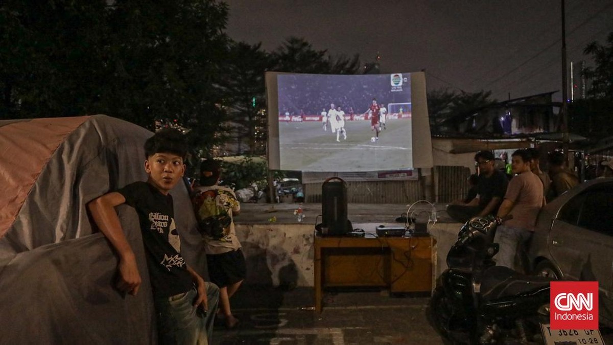Warga menyaksikan pertandingan Timnas Indonesia melawan Thailand dalam final FIFA ASEAN Cup 2026 di Jakarta, Senin (5/10/2026). (CNN Indonesia/Febria Adha L).