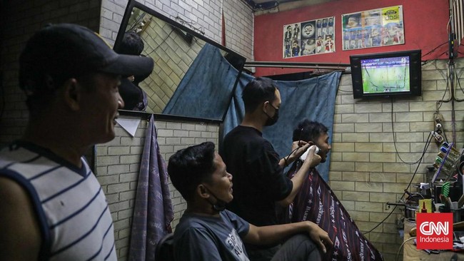 Warga menyaksikan pertandingan Timnas Indonesia melawan Thailand dalam final FIFA ASEAN Cup 2026 di Jakarta, Senin (5/10/2026). (CNN Indonesia/Febria Adha L).