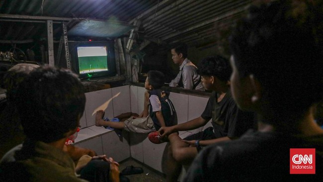 Warga menyaksikan pertandingan Timnas Indonesia melawan Thailand dalam final FIFA ASEAN Cup 2026 di Jakarta, Senin (5/10/2026). (CNN Indonesia/Febria Adha L).