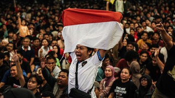Seorang warga membentangkan bendera Merah Putih saat nonton bareng pertandingan final FIFA ASEAN Cup 2026 antara Timnas Indonesia dan Timnas Thailand di halaman Kantor Gubernur dan DPRD Provinsi Jawa Tengah, Semarang, Jawa Tengah, Senin (5/10/2026).