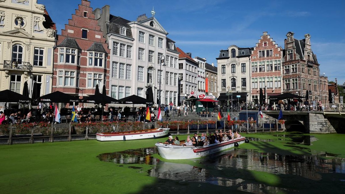 A sightseeing boat travels along a duckweed-covered section of the River Lys in Ghent, Belgium, October 5, 2026. Prolonged hot and dry weather led to a surge in duckweed growth on the river following one of Europe's driest summers on record. REUTERS/