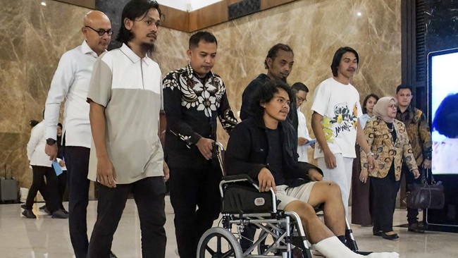 Indonesia's Foreign Minister Arrmanatha Nasir (L, in white shirt) accompanies injured an Indonesian seaman (C, in wheelchair) upon his arrival with three other seamen at Soekarno-Hatta International Airport in Tangerang, Banten, on October 6, 2026, f