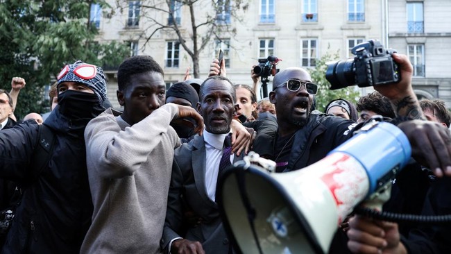 Saint-Denis Mayor Bally Bagayoko stands between protesters and police officers during a demonstration of high-school students, in Paris on October 6, 2026, as part of a nationwide protest movement over learning conditions. Since late September, pupil