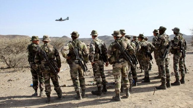 French soldiers look at a Transall plane in-flight refuelling at a military base in the desert of Djibouti (CAIDD) which trains soldiers how to survive during battle in extreme terrain. AFP PHOTO/Jacques Demarthon (Photo by JACQUES DEMARTHON / AFP)