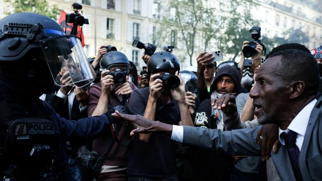 Saint-Denis Mayor Bally Bagayoko stands between protesters and police officers during a demonstration of high-school students, in Paris on October 6, 2026, as part of a nationwide protest movement over learning conditions. Since late September, pupil