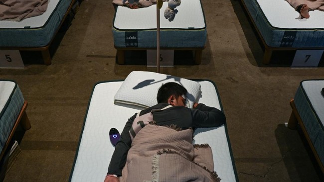 An attendee takes part in a sleep competition organized by a mattress brand in Tokyo on October 5, 2026. (Photo by Selim CHTAYTI / AFP)