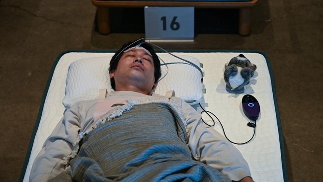 An attendee takes part in a sleep competition organized by a mattress brand in Tokyo on October 5, 2026. (Photo by Selim CHTAYTI / AFP)