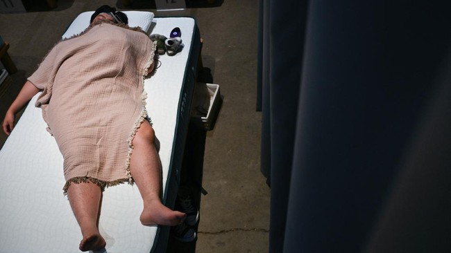 An attendee takes part in a sleep competition organized by a mattress brand in Tokyo on October 5, 2026. (Photo by Selim CHTAYTI / AFP)