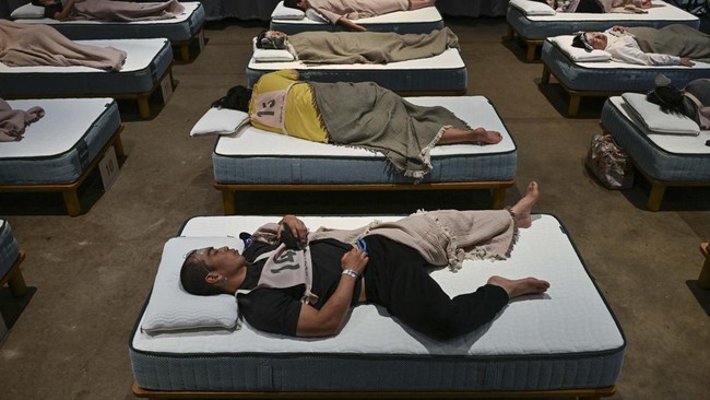Attendees take part in a sleep competition organized by a mattress brand in Tokyo on October 5, 2026. (Photo by Selim CHTAYTI / AFP)